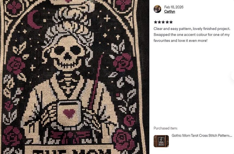 K&ouml;nnte beinhalten: Kreuzstichmuster mit einer Skelettfigur mit Krone, die eine Tasse mit einem Herzen h&auml;lt, und dem Text "THE MOM". Das Design umfasst Rosen, Sterne und einen Mond, alles im gotischen Stil. Die Farbpalette umfasst Schwarz, Creme und Burgunderrot.
