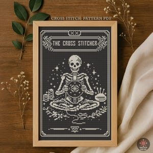 May include: A framed cross-stitch pattern PDF featuring a skeleton meditating with a needlework design. The image is in black and white, with the text "THE CROSS STITCHER" at the top. The frame is light brown, and the background is a dark wood.
