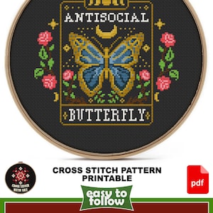 May include: Cross stitch pattern printable for a 6 inch by 6 inch Aida cloth. The pattern features a butterfly with a yellow body and blue wings, surrounded by roses and the text "ANTISOCIAL BUTTERFLY".