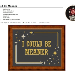 May include: Cross-stitch artwork in a wooden frame. The design features the text "I COULD BE MEANER" in gold lettering on a dark grey background, with star accents. The design area is 25.04 cm x 15.06 cm. A smaller, circular cross-stitch design is in the upper right.