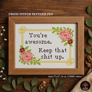 Op de afbeelding: Een ingelijst kruissteekpatroon met de tekst "You're awesome. Keep that shit up." Het ontwerp bevat roze rozen en groene bladeren. De lijst is bruin en de afmeting is 17.78cm x 12.7cm.