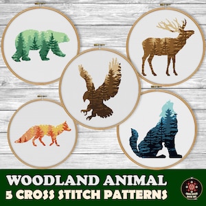 May include: Five cross stitch patterns featuring woodland animals: a bear, a deer, an eagle, a fox, and a wolf. Each animal is outlined in black and filled with a colorful forest scene.