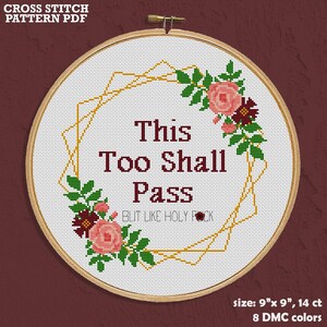 Könnte beinhalten: Ein Kreuzstichmuster in einem Holzrahmen mit dem Text This Too Shall Pass but like holy f*ck in dunkelroten Buchstaben. Ein goldener geometrischer Rahmen umgibt den Text, akzentuiert durch rosa und dunkelrote Blumen mit grünen Blättern.