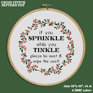 May include: Cross stitch pattern PDF for a bathroom sign that reads "If you sprinkle while you tinkle, please be neat & wipe the seat!" The sign is surrounded by a wreath of green leaves and red berries. The pattern is 10 inches by 10 inches and uses 14 count fabric with 4 DMC colors.