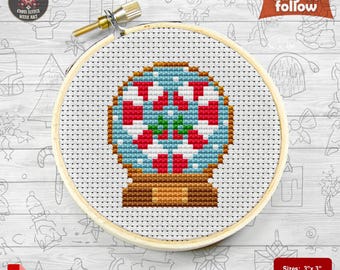 May include: A cross stitch pattern for a candy cane snow globe. The pattern is for a 3 inch by 3 inch project and uses 9 DMC colours. The pattern is easy to follow and includes a PDF download.