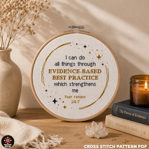 May include: A circular wooden embroidery hoop containing white fabric with cross-stitched text that reads: I can do all things through EVIDENCE-BASED BEST PRACTICE which strengthens me Peer review 24:7, surrounded by gold and dark blue star motifs.