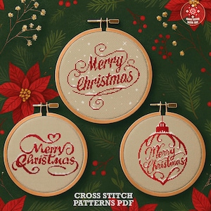 May include: Three circular wooden embroidery hoops containing cross stitch patterns on beige fabric. Each hoop features the text Merry Christmas in red thread with decorative flourishes. One hoop displays the text inside a red ornament shape.