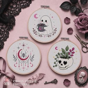 May include: Three circular wooden embroidery hoops containing cross-stitch patterns. One features a ghost holding a mug, another a spider on a crescent moon, and the third a skull planter with green leaves. The text CROSS-STITCH WITH ART is visible.