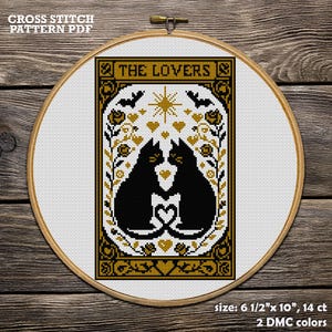 A cross-stitch PDF pattern featuring two black cats facing each other, forming a heart with their tails. The design includes bats, stars, and floral elements in gold and black.  Cat Cross Stitch Pattern PDF. The Lovers Gothic Tarot Embroidery Design. Funny Halloween Decor. Mystic Cat, Romantic Gift for Couples