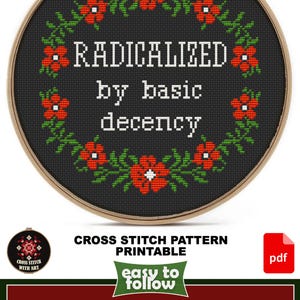 A cross-stitch pattern in a wooden hoop with the text "RADICALIZED by basic decency" surrounded by red flowers and green leaves. The design size is 7" x 7". The pattern is printable and easy to follow.