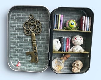 Miniature cabinet of curiosities, with skull, mummy, dragon egg, vial, eye and small books