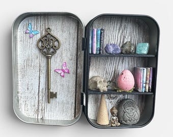 A miniature "zen" cabinet of curiosities, featuring real calming stones, a relaxing incense cone, and sculptures of yogis.