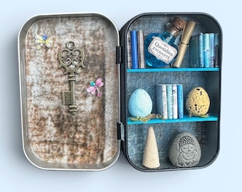 A miniature "zen" cabinet of curiosities, with a bottle of Enchanted Daily, a relaxing incense cone, and a yogi sculpture.