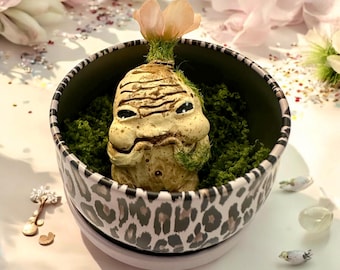 Babybeige en aardse Mandrake met oranje bloem, met de hand gebeeldhouwd en beschilderd, in zijn metalen pot met groene mosvlokken