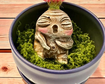 Babybeige Mandrake met roze wangen en fuchsia bloem, met de hand gebeeldhouwd en beschilderd, in zijn metalen pot met groene mosvlokken