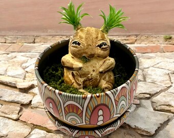 Babybruine alruin met staartjes, met de hand gesneden en beschilderd, in zijn metalen pot met groene mosvlokken