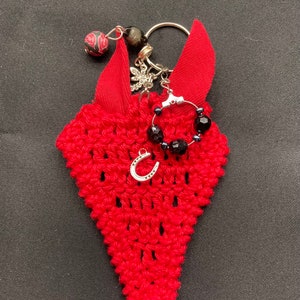 Red keychain with horseshoe, red mini riding cap. Horseshoe brings good luck