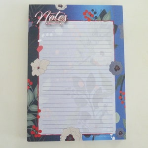 May include: A blue and white notepad with a floral design and the word "Notes" in a decorative font.