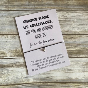 May include: A white card with black text that reads "Chance made us colleagues, but fun and laughter made us friends forever."  The card is attached to a black string with a silver star charm. The text below the card reads "The more you wish, the more you dream. The bigger the star on your wrist will seem. When the cord breaks in two, all your dreams and wishes will come true."
