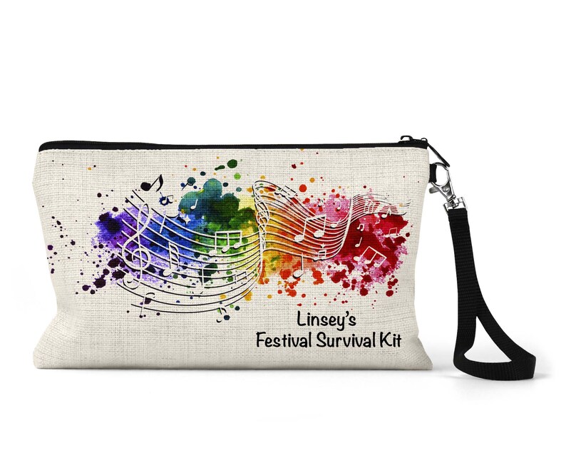 Op de afbeelding: Een witte canvas toilettas met een zwarte rits en een zwarte band. De tas heeft een kleurrijk aquarelontwerp met muzieknoten en de tekst "Linsey's Festival Survival Kit".