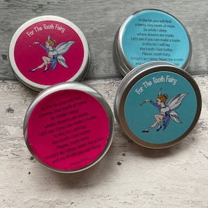 May include: Three small, silver tins with colourful labels featuring a tooth fairy illustration and the text "For The Tooth Fairy". The labels include a rhyme about leaving a tooth for the tooth fairy.