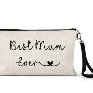 May include: A beige canvas makeup bag with a black zipper and a black strap. The bag has the text "Best Mum Ever" in black cursive writing with a small black heart.