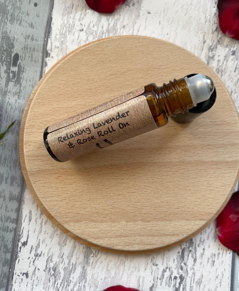 May include: A brown glass roll-on bottle with a silver roller ball. The bottle is labelled "Relaxing Lavender & Rose Roll On".