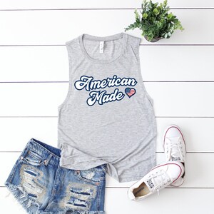 May include: Gray sleeveless tank top with the text "American Made" in a retro font and a small American flag heart graphic.