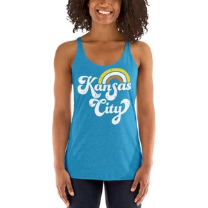 Puede incluir: Un top de tirantes azul turquesa con un gr&aacute;fico blanco desgastado que dice "Kansas City" con un arco&iacute;ris sobre el texto.
