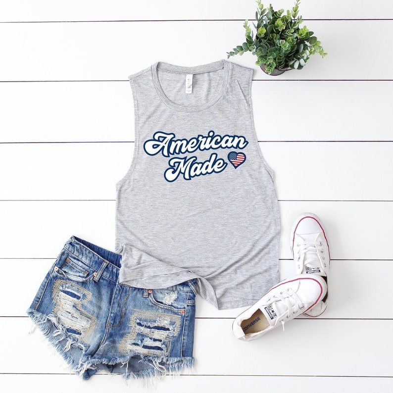 May include: Gray sleeveless tank top with the text "American Made" in a retro font and a small American flag heart graphic.