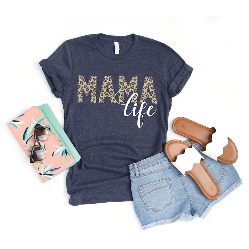 May include: A navy blue t-shirt with the text "NAMA life" in white lettering. The word "NAMA" is printed in a leopard print pattern.