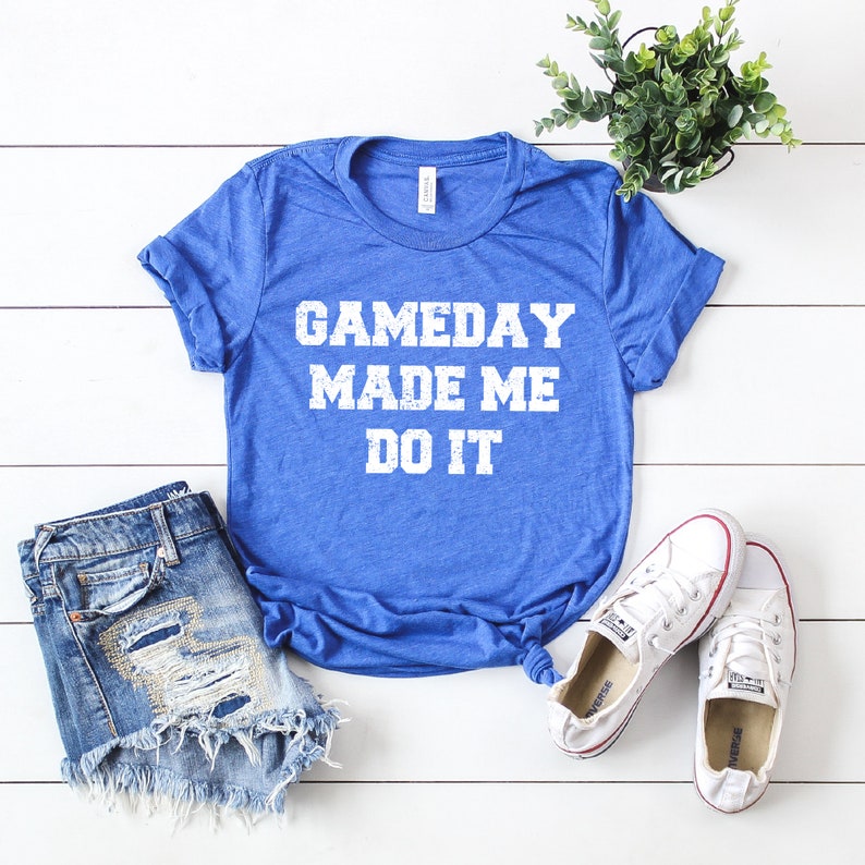 May include: A royal blue t-shirt with the text "GAMEDAY MADE ME DO IT" in white distressed lettering.