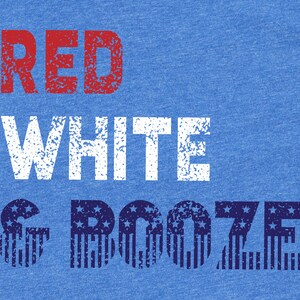 May include: Blue t-shirt with the words "RED", "WHITE", and "& BOOZE" in a distressed font. The word "RED" is in red, "WHITE" is in white, and "& BOOZE" is in blue with a star and stripe pattern.