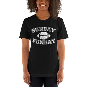 Op de afbeelding: Zwart T-shirt met een witte, verweerde afbeelding van een voetbal en de tekst "SUNDAY FUNDAY".