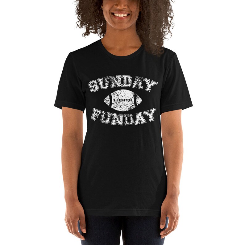 Op de afbeelding: Zwart T-shirt met een witte, verweerde afbeelding van een voetbal en de tekst "SUNDAY FUNDAY".