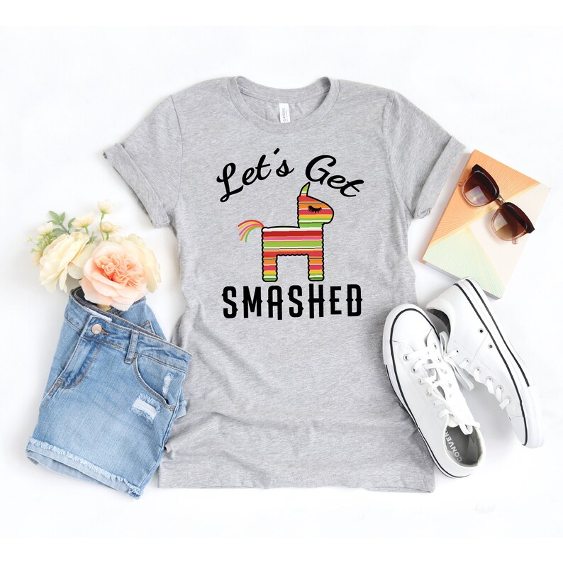May include: Gray t-shirt with a black graphic of a pinata with the text "Let's Get Smashed".