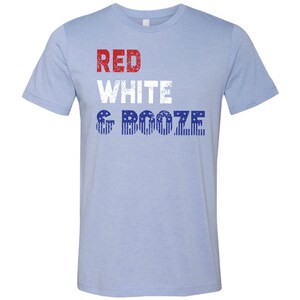 May include: Light blue t-shirt with the text "RED WHITE & BOOZE" in red, white, and blue with a distressed American flag pattern.