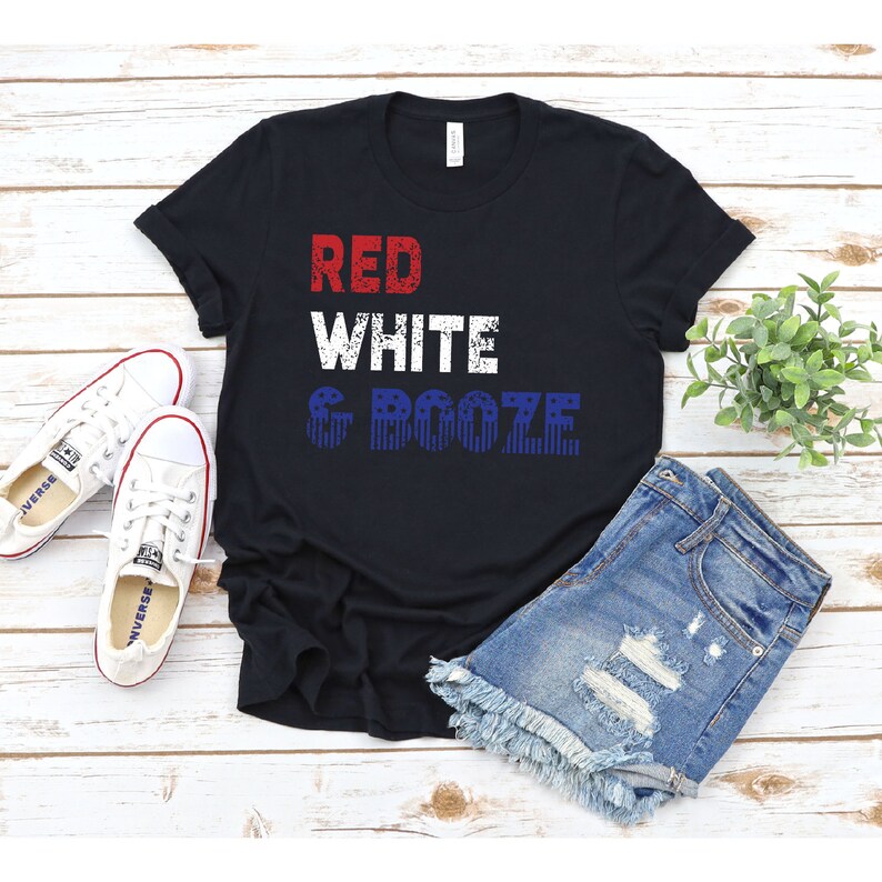 May include: Black t-shirt with the text "RED WHITE & BOOZE" in red, white, and blue with a distressed look. The text is overlaid with a pattern of red, white, and blue stars.