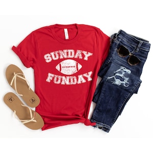 Op de afbeelding: Rood T-shirt met een witte afbeelding van een voetbal en de tekst "SUNDAY FUNDAY".
