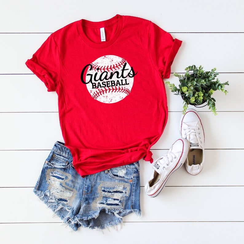 May include: Red t-shirt with a white baseball graphic and the text "Giants Baseball" in black.
