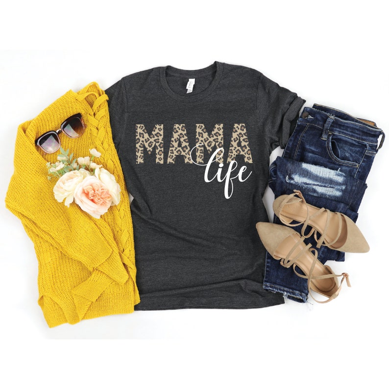 May include: A dark gray t-shirt with the word "MAMA" in leopard print and the word "life" in white text.