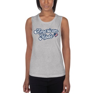May include: Gray sleeveless muscle tank top with the text "American Made" in blue script with a small American flag heart.
