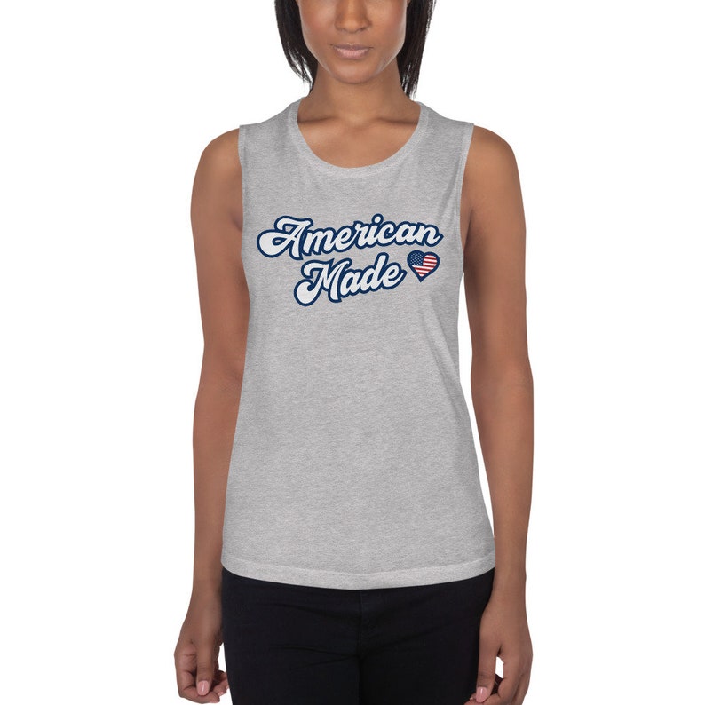 May include: Gray sleeveless muscle tank top with the text "American Made" in blue script with a small American flag heart.