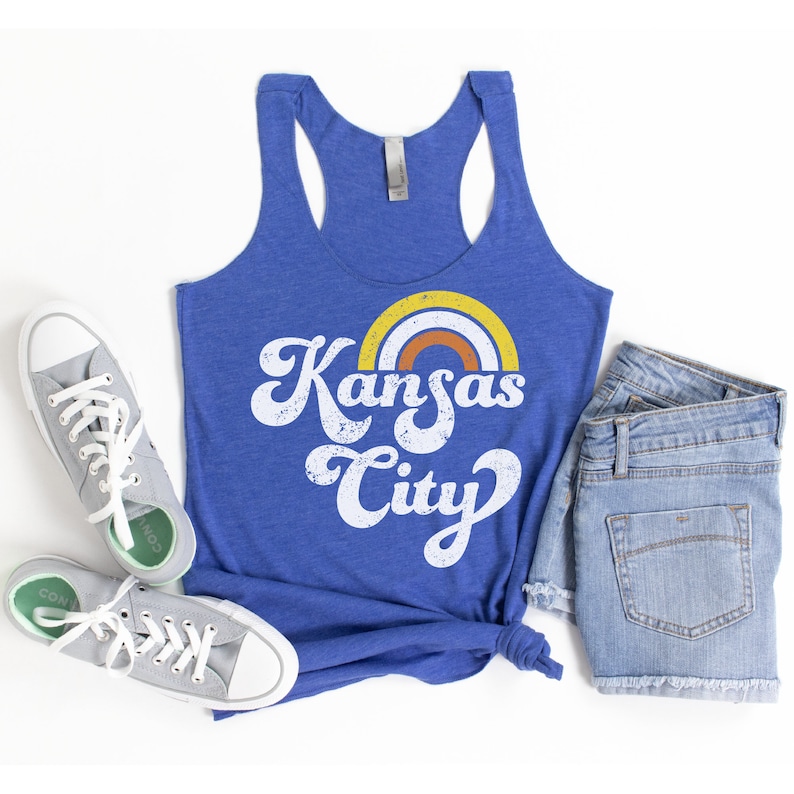 Puede incluir: Un top de tirantes azul real con un gr&aacute;fico blanco desgastado de un arco&iacute;ris y el texto "Kansas City".