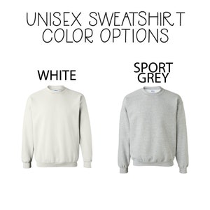 May include: Two sweatshirts, one white and one sport grey, are shown against a white background. The text "UNISEX SWEATSHIRT COLOR OPTIONS" is at the top of the image. The text "WHITE" is above the white sweatshirt and the text "SPORT GREY" is above the grey sweatshirt.