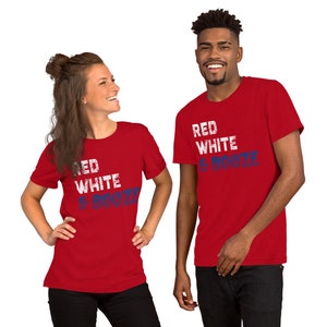 May include: Two people wearing red t-shirts with the text "Red White & Booze" in blue and white lettering. The shirts have a distressed look.