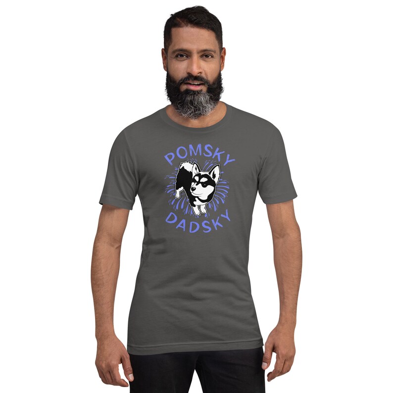 May include: A dark gray t-shirt with a cartoon image of a Pomsky dog in a blue circle with the text "Pomsky Dadsky" in blue.