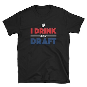 Könnte beinhalten: Schwarzes T-Shirt mit rotem und blauem Text, der "I Drink and Draft" lautet, mit einer weißen Fußballgrafik über dem Text.