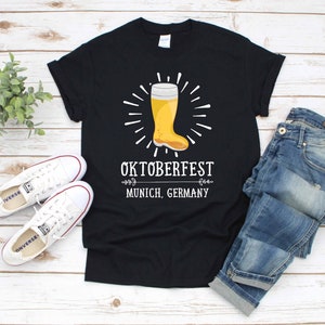 May include: Black t-shirt with a white graphic of a beer stein and the text "Oktoberfest Munich, Germany".