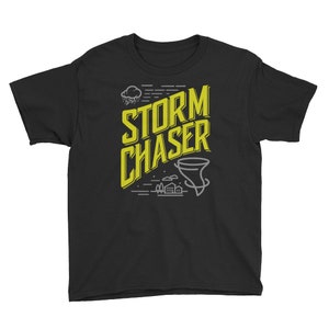 May include: Black youth t-shirt with a yellow graphic design that says "STORM CHASER" with a stylized image of a tornado and a cloud with rain.